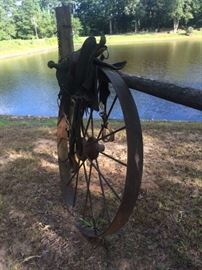 Large Carriage Wagon Wheel, One of Several Vintage Saddles Decorating the Fencing.