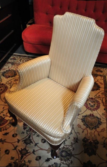 Upholstered wing chair in gold and cream