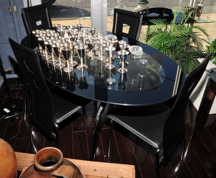 Oval glass table with four chrome and leather chairs.
