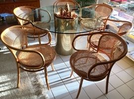 Glass round pedestal dining table with brass base