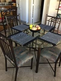 Wrought Iron round kitchen table, with glass top,  4 padded chairs, beautiful condition 