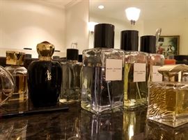 MANY bottles of perfume and other toiletries - many unopened.