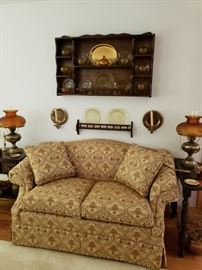 Print upholstery love seat in gold and olive green.