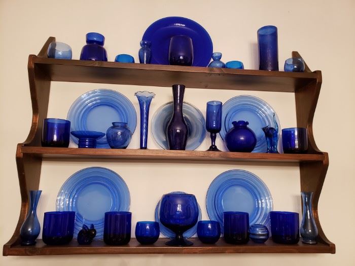 Blue colored glass collection of glasses, plates, cups and vases. 