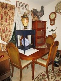 Dining room table in very good condition w/ 4 chairs, one leaf & table pads, misc. tables, small cupboard, misc decor, several area rugs