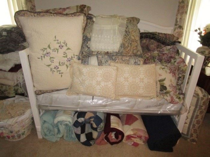Crib/toddler bed, many beautiful pillows, bedding, linens, quilts