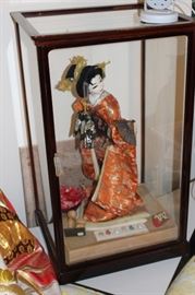 Asian porcelain doll in glass case