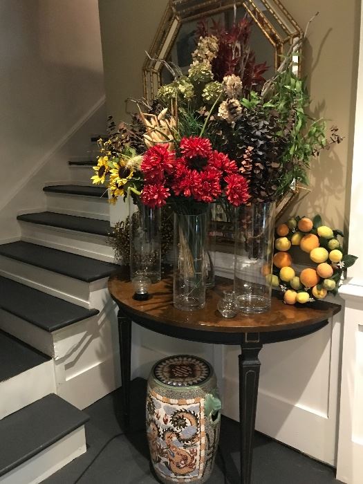 Foyer table filled with silk flowers of the fall season. Behind a Labarge mirrior And below who wonderful Asian garden bench