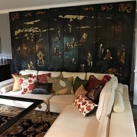 Wonderful old multipaneled screen with a cream linen Restoration Hardware sectional sitting in front of it. The sofa
Is covered with pillows with colours of the season. 