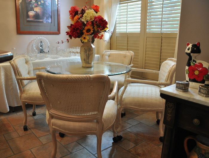 A terrific glass top (with beveled edge) pedestal table and 4 chairs in the kitchen dining area.  There is a larger glass top available for this table.  The table is now full of more American Fostoria pieces.