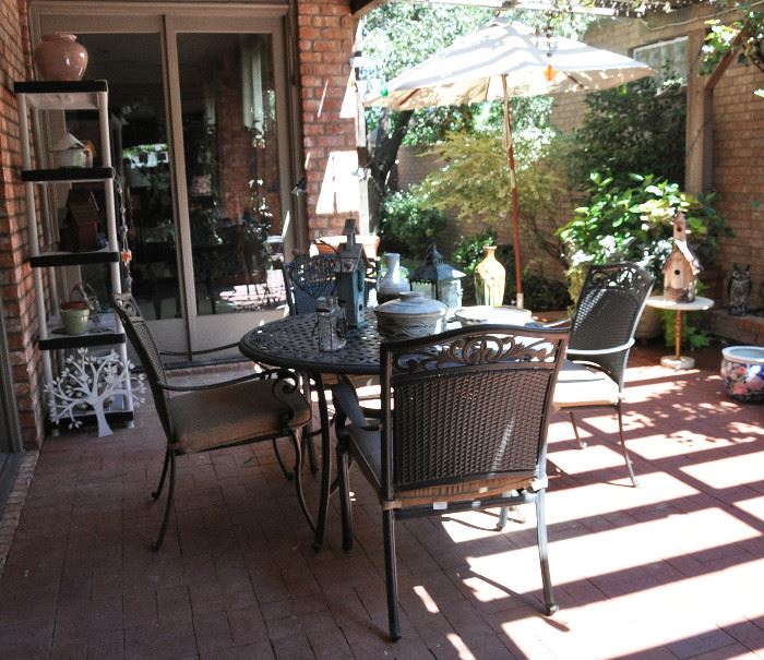 The view of the lovely garden area featuring a Martha Stewart Living round table with 4 cushioned chairs.  There is also a collection of bird houses and pots along with a brand new, never installed sun shade.