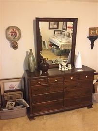 dresser with mirror and various decor items 