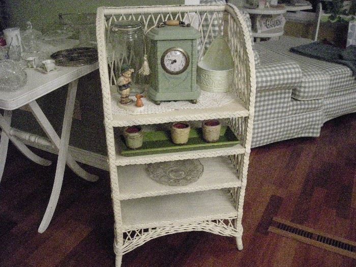 wicker bookcase, candles, Hummel figurine, clock