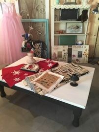 Vintage linens, refinished coffee table, vintage patch-work teddy bear, vintage dress, turquoise frame, vintage metal screen door, vintage shelving unit, various pictures.