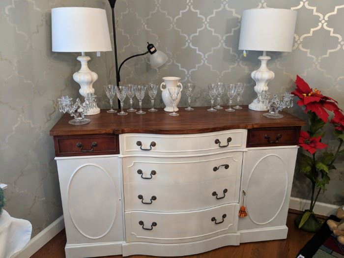 This is a wonderful vintage buffet that is painted in a soft white. The top has been refinished to show the original Mahogany veneer. It has a beautiful waxed finish. The two side drawers are the original finish to add style and maintain some of its great history. This is a very nice clean piece with its original key.
