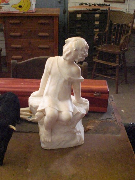 Marble statue of girl sitting on rock