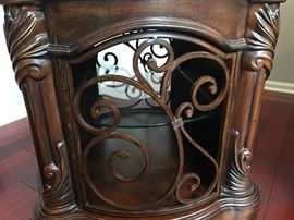 Michael Amini Essex Manor Traditional English Tea Barrel End Table by AICO. Show off your sophisticated taste with that Essex manor barrel end table, which is inspired from traditional European design ethos. Intricate detailing and soft, curved contours mark this gorgeous table, which would easily blend and most traditionally-styled decor themes. While the top of the table can be used for decorative purposes, the storage compartment with a glass shelf inside can be used for keeping your silverware and other items handy. Built to stand the test of time, the Essex manor barrel end table sports a deep English tea finish that emphasizes it’s ornate aesthetics. Constructed with Birch solids, Birch and cherry veneers. Intricate leaf wood carvings. Dark color tone. Barrel shaped end table.