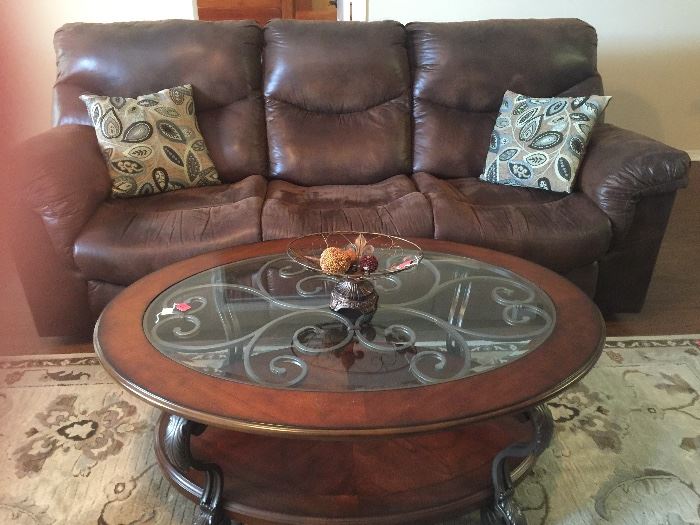 Leather recliner sofa and glass and wood coffee table with metal accents 