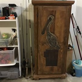 Cabinet with carved Pelican, Fishing Rod and Reels