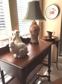 Pair of large whimsical glazed ceramic rabbits, porcelain floral table lamp, and one of two antique oak sideboards with brass handles.
