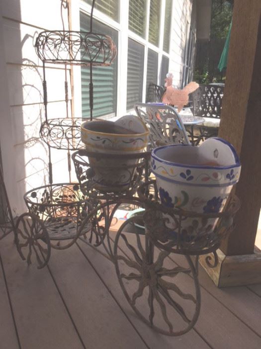 Ornate 3-tier metal plant stand, and yard bicycle planter for three pots.