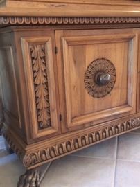 Detail of large modern buffet cabinet, heavily carved, with claw feet