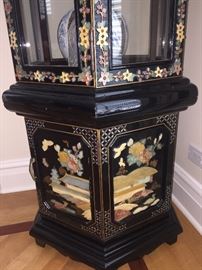 A corner six-sided curio Asian Stone and Mother of Pearl inlay black lacquered display cabinet. Height 75 x Diameter 24 inches. In excellent condition. 