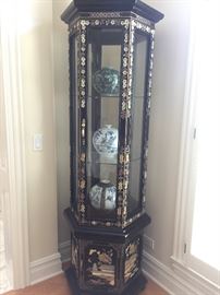 A corner six-sided curio Asian Stone and Mother of Pearl inlay black lacquered display cabinet. Height 75 x Diameter 24 inches. In excellent condition.
