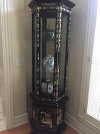 A corner six-sided curio Asian Stone and Mother of Pearl inlay black lacquered display cabinet. Height 75 x Diameter 24 inches. In excellent condition. 