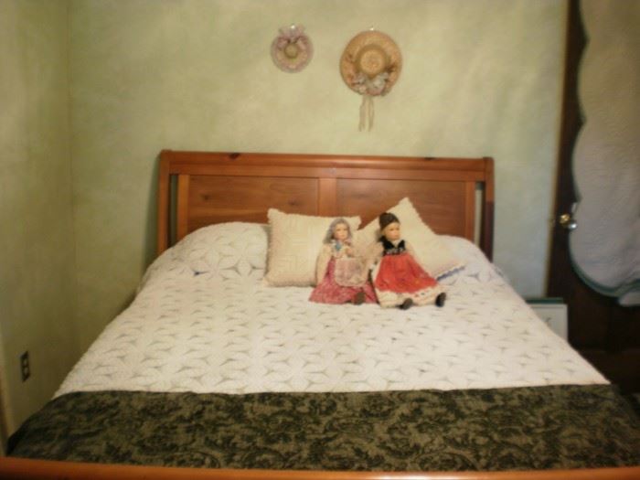 Queen size sleigh bed.  Antique dolls in Eastern Europe dress.