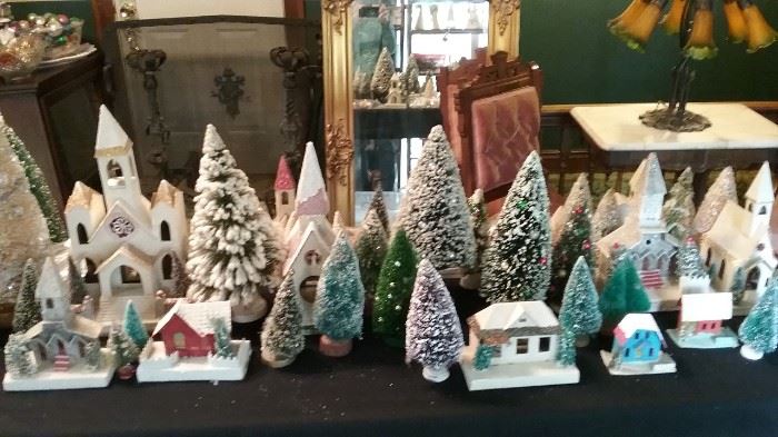 An assortment of Putz churches and houses accompanied by vintage bottle brush trees.