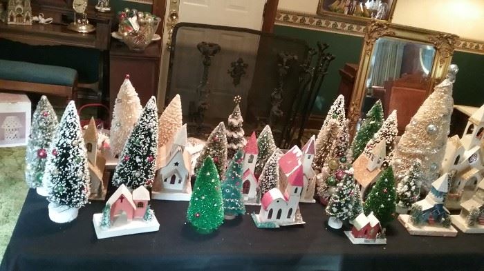 An assortment of Putz houses and churches interspersed with bottle brush trees.