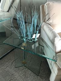 Glass table with beveled glass top displaying cat tail motif sculpture