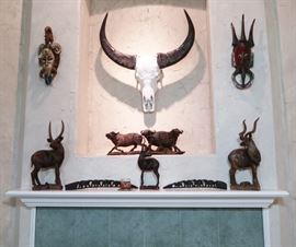 Carved African figures, African tribal masks and pictured at center top is a Water Buffalo