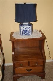 One of two maple night stands and one of two matching blue/white ceramic lamps.