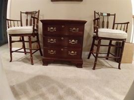 Pair of very cool vintage stools, with faux bamboo legs, gold detailing and cane seating, squished beside a 2-drawer Ethan Allen mahogany chest.