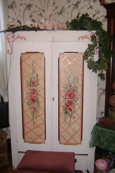 A PAINTED WHITE ARMOIRE THAT WAS CONVERTED INTO A TV CABINET WITH HAND PAINTED PINK FLOWERS