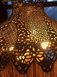 Detail #1 of the tall, pierced Middle Eastern brass lamp in the dining room.  Lamp was polished to a bright finish after present owner acquired it some decades ago. 