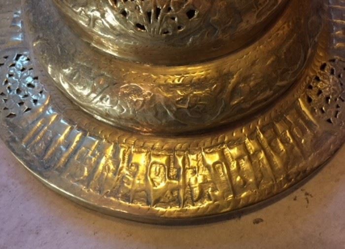 Detail #3 of the tall standing pierced Middle Eastern brass lamp in the dining room, showing unknown writing on the base. Could it be in Hebrew? Aramaic? Syriac?  Amharic? Or something else entirely?