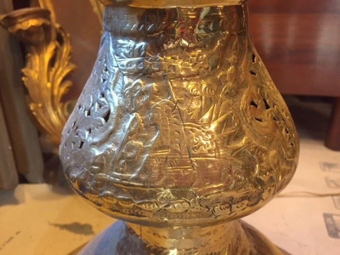 Detail #2 of the tall, pierced Middle Eastern brass lamp in the dining room, showing figural imagery.