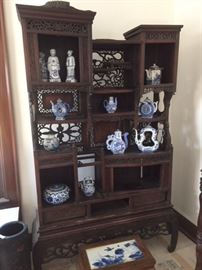 Antique Chinese carved wood display case with lattice decoration,  holding Chinese blue & white ceramics. In the living room. 