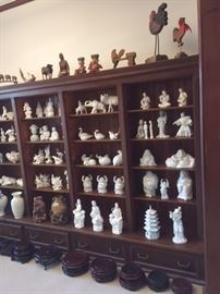 Asian white porcelain figurines, Chinese soapstone carvings and wooden figures on display in the library. 
