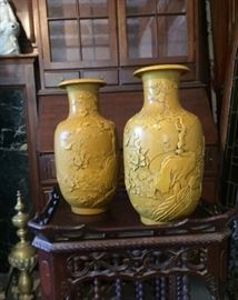 Pair of yellow Chinese ceramic vases of unknown age with carved figural imagery. Inscribed "Wang Bing Rong" on the bottom. Wang Bing Rong was a celebrated Qing dynasty ceramic artist whose work was often imitated in the decades following his death. 