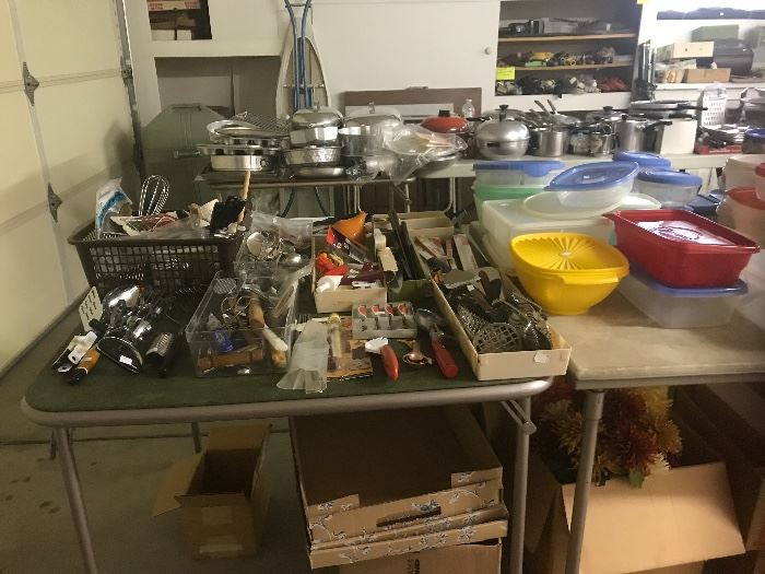 Table filled with various kitchen items, including knives and anything you could possibly need.  Also more of the plastic items.
