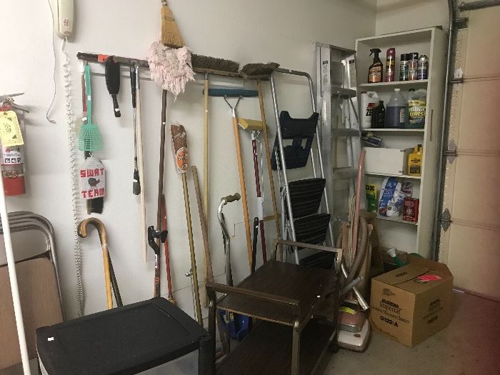 Shelf has various garden products.  On the floor a pink Hoover vac and in the box a Eureka canister vacuum, both of which work perfections.  Small movable TV tables.  Mops, brooms, ladders.  Sorry, folding chairs are no longer available. 3 cabes,