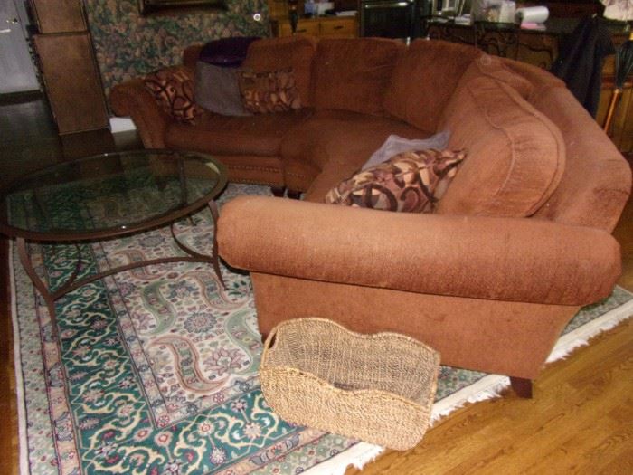 Home Wear burnt orange sectional sofa with nail head trim. 8x10 wool rug.