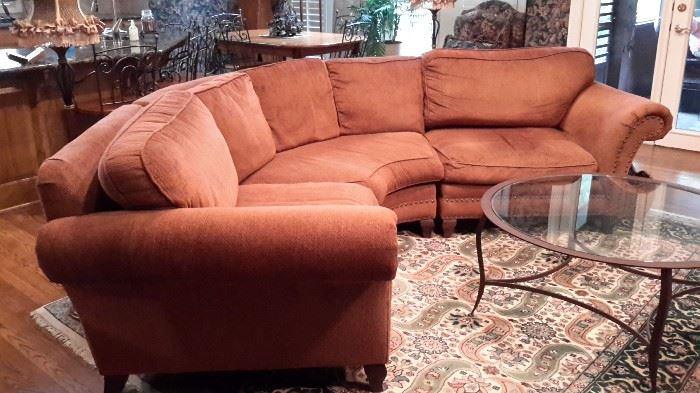 Home Wear burnt orange sectional sofa with nail head trim. 8x10 wool rug. 
