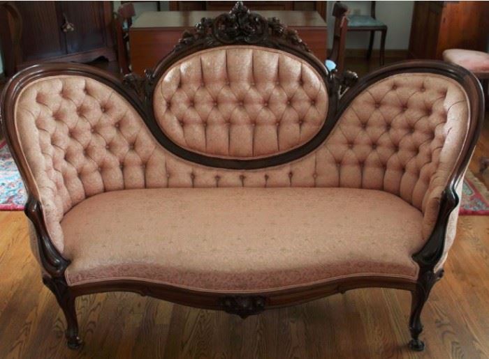 29 - SETTEE - Circa Mid 1800's, rosewood, finger molded frame with highly carved central crestail. cabriole legs, on casters, rose damask tufted upholstery.