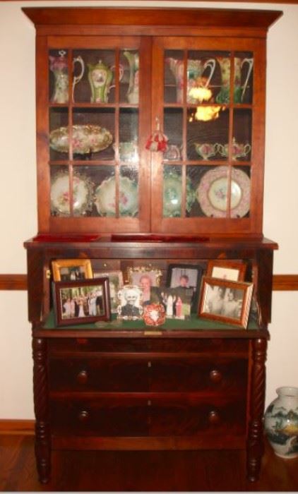 108 - SECRETARY - Circa 1850, burl mahogany, architectural cornice over two mullioned glass doors, mounted on a case with fall front revealing pigeon holes and drawers, over three stacked and graduated drawers flanked by spiral turned columns, ringed and turned feet.