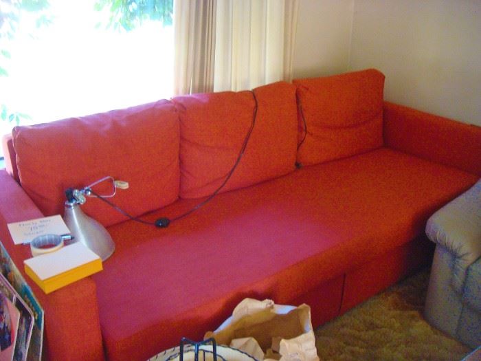 Nearly new orange hide a bed couch